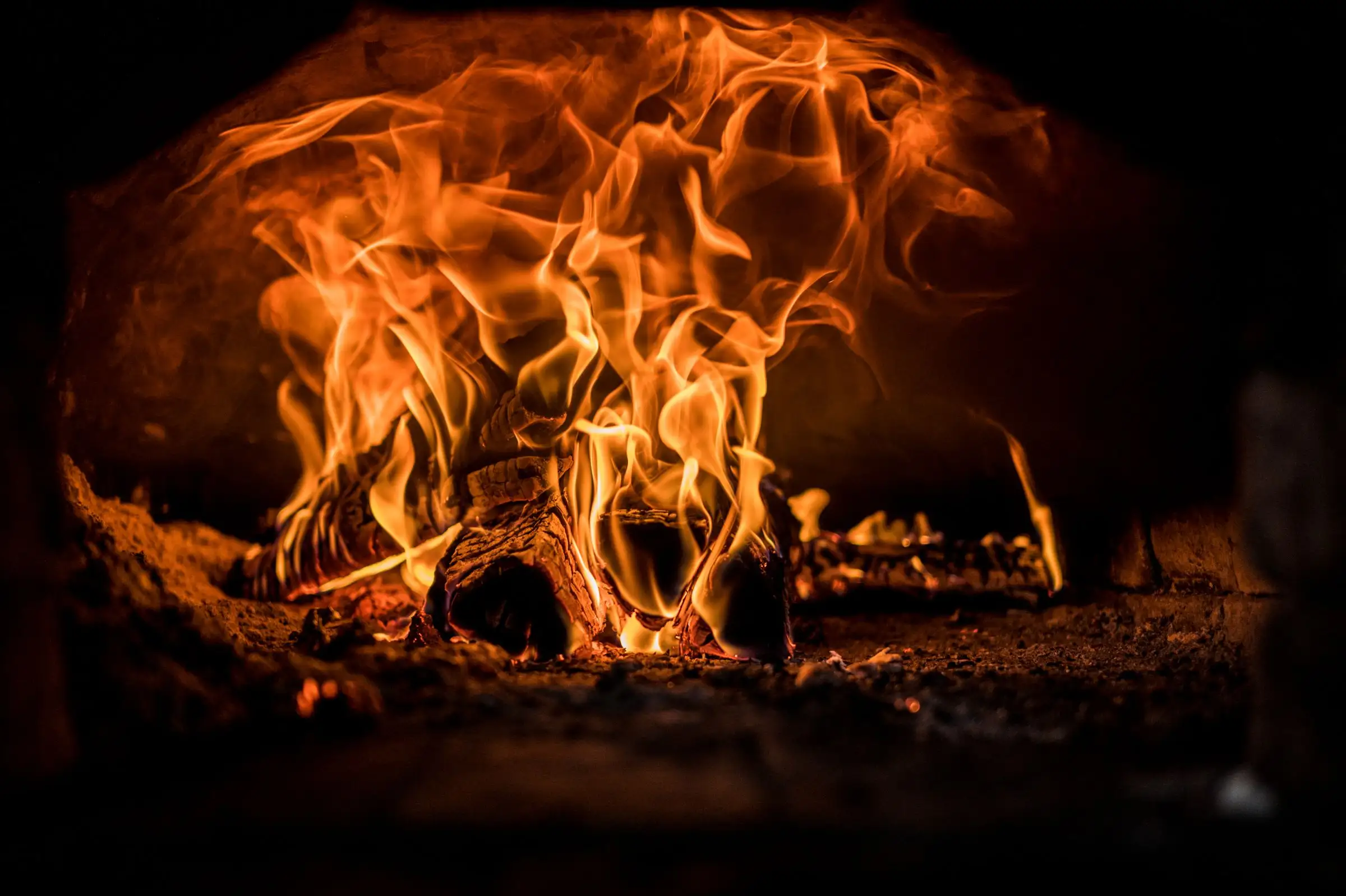 Flames curling up from burning oak inside the restaurant’s brick oven